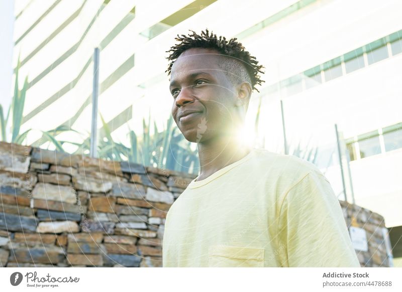 Black man standing near stone wall positive carefree optimist guy black laugh trendy casual happy african american delight satisfied lifestyle street youth