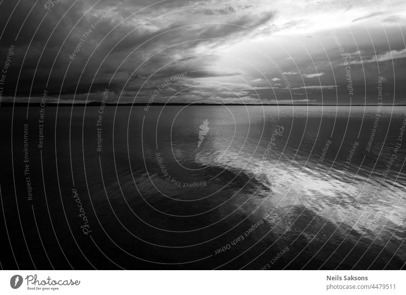 black and white cloudscape or waterscape. Calm waveless lake mirror surface reflects beautiful clouds in evening summer sunset light cloudy calm tranquil shore