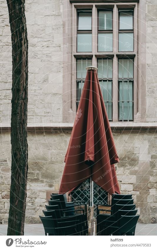 Closing time - closed umbrella and stacked chairs in the outdoor gastronomy Umbrellas & Shades Sunshade Closed Stack chairs - outdoor outside gastronomy