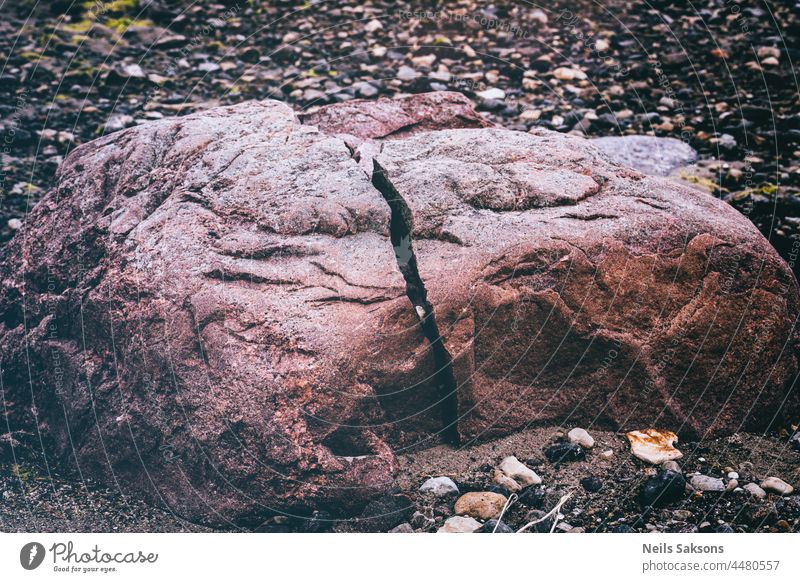 naturally splitted red boulder on Baltic sea coast. Small rocks and pebbles around abstract background beach beautiful broken brown close-up closeup