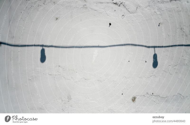 shadow of cable and light bulb on the rustic white wall horizontal abstract line indoors sunlight shape bright illuminated material no people reflection shade