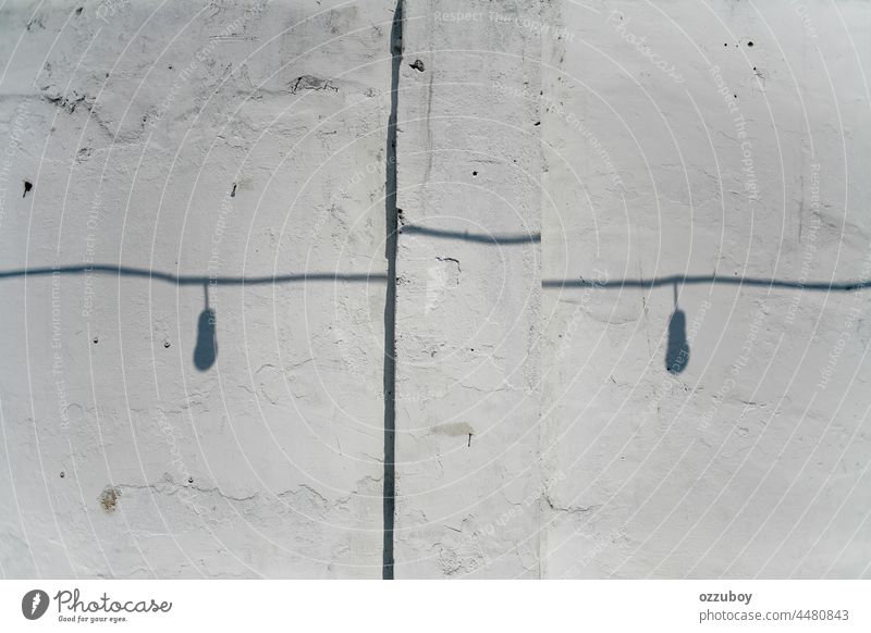 shadow of cable and light bulb on the rustic white wall horizontal abstract line indoors sunlight shape bright illuminated material no people reflection shade