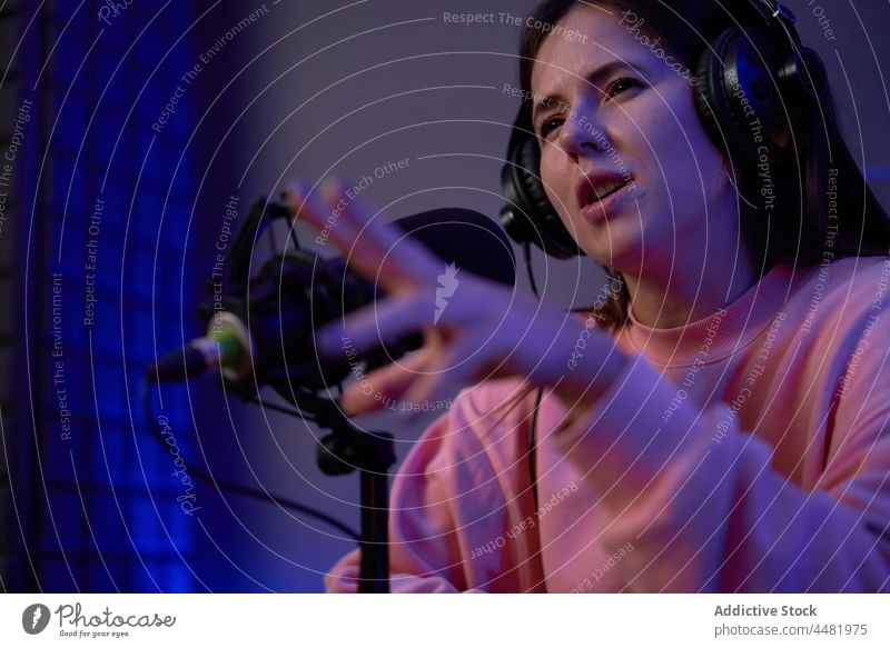 Woman recording podcast in studio woman smile sound microphone radio host colleague together headphones female young casual headset broadcast work positive