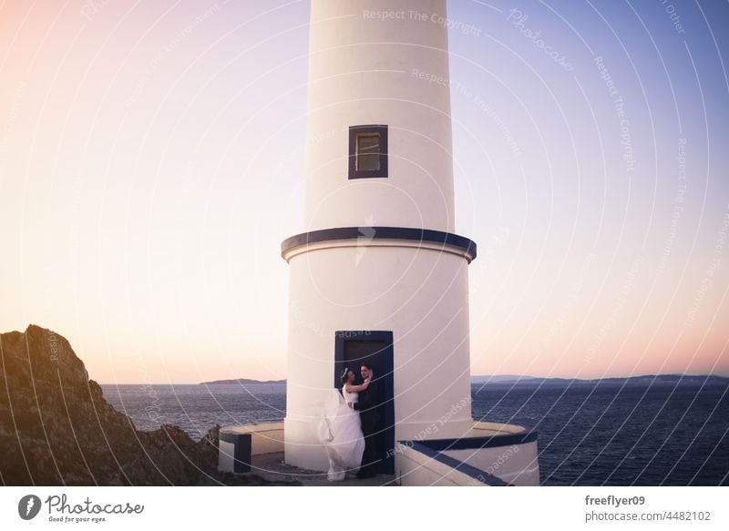 Just married couple on a lighthouse door wedding husband wife apparel love copy space ocean sea landscape heterosexual bride groom forest tree sunset portrait