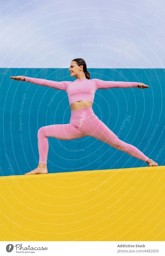 Smiling woman practicing yoga in Warrior pose flexible warrior pose stretch practice balance smile cheerful asana female virabhadrasana harmony wellness vivid