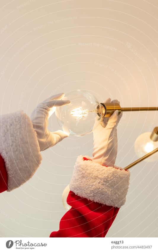 Santa Claus is changing a light bulb arm assistant beer glass celebrating cheer christmas christmastime claus cocktails cool cup december drinking enjoyment