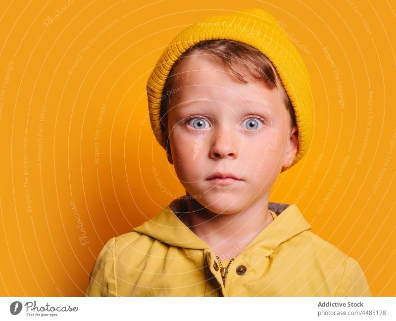 Surprised boy looking at camera against yellow wall in studio amazed surprise astonish colorful shock style autumn portrait childhood omg wow individuality