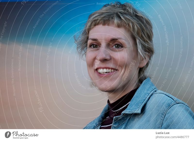 Blue hour, happy laughter: Woman with short hair looks into the camera with amusement cheerful Smiling smilingly amused Short-haired pretty Charming Happy