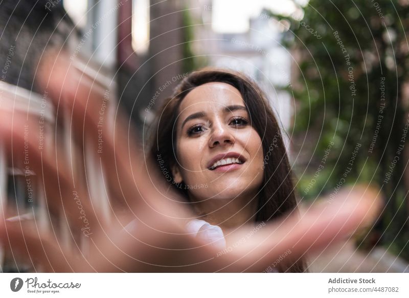 Happy woman looking at camera street smile happy hand building downtown calm modern trendy charming female glad urban pull city positive young style