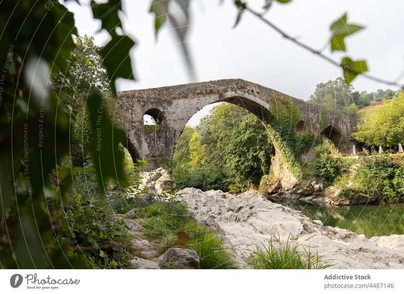 Ancient Roman bridge over river roman historic aged water old coast ancient shore cangas de onis nature tree spain asturias sella stone construction rock