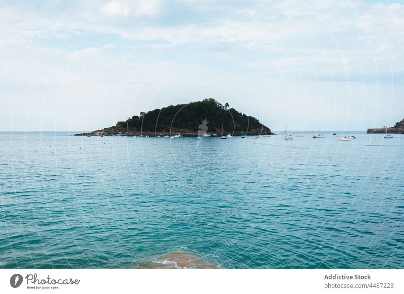 Sandy beach washing by calm water of ocean nature island coast scenery picturesque shore sea san sebastian spain donostia basque country bay of biscay landscape