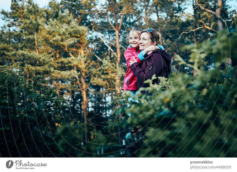 Woman and her dughter admiring landscape actively spending summer vacation together walking down a forest path family outdoor activity nature leisure beauty