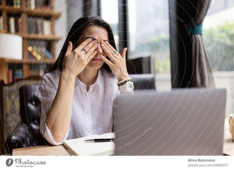 Young Caucasian business woman with long brunette hair working on laptop in cafe. College student using technology online businesswoman phone professional young