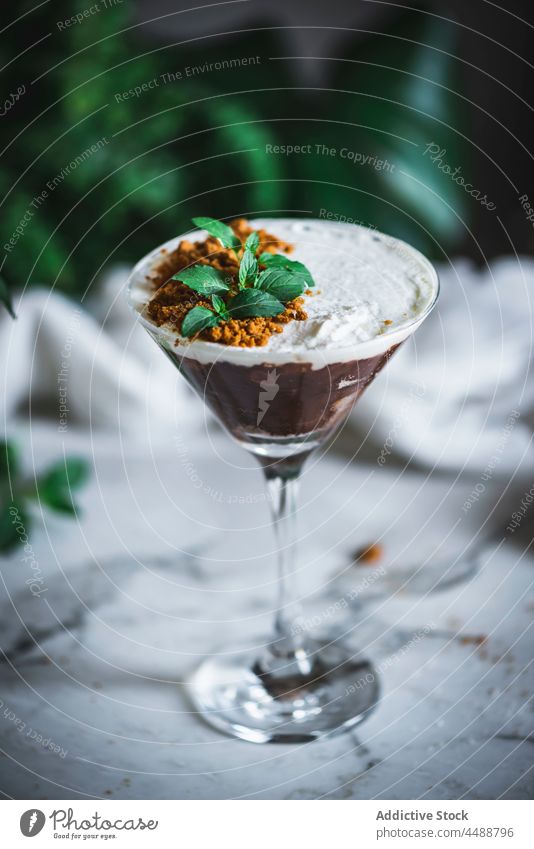 Tasty chocolate and coconut mousse dessert sweet treat glass delicious mint garnish leaf yummy gourmet fresh tasty portion food serve table green plant