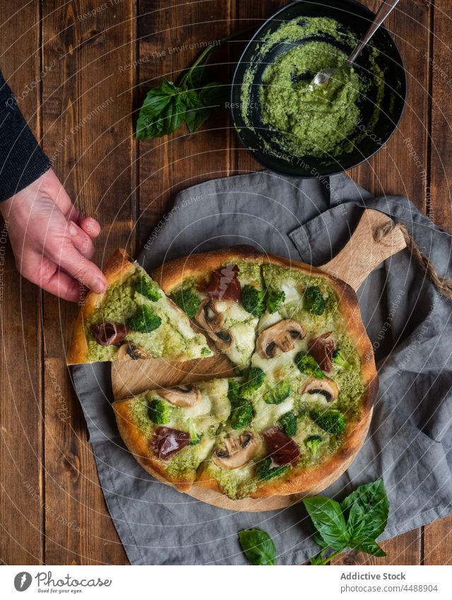 Crop person with slice of vegetarian pizza pesto sauce mushroom broccoli piece table tasty delicious cuisine serve meal gourmet food gastronomy take champignon