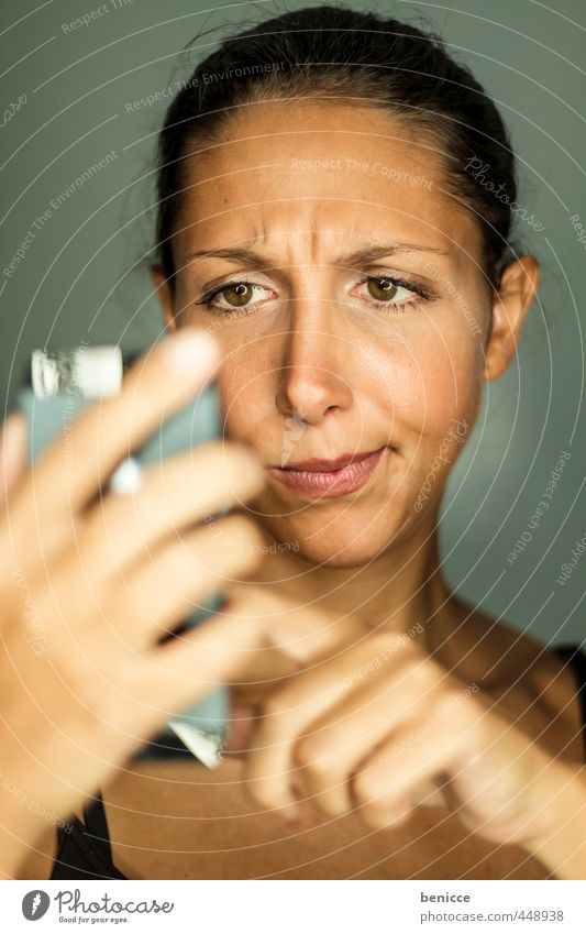 Young woman looks skeptically at her smartphone Woman Human being PDA Cellphone Telephone Clerk portrait Write iPhone Typing Dark-haired SMS Skeptical