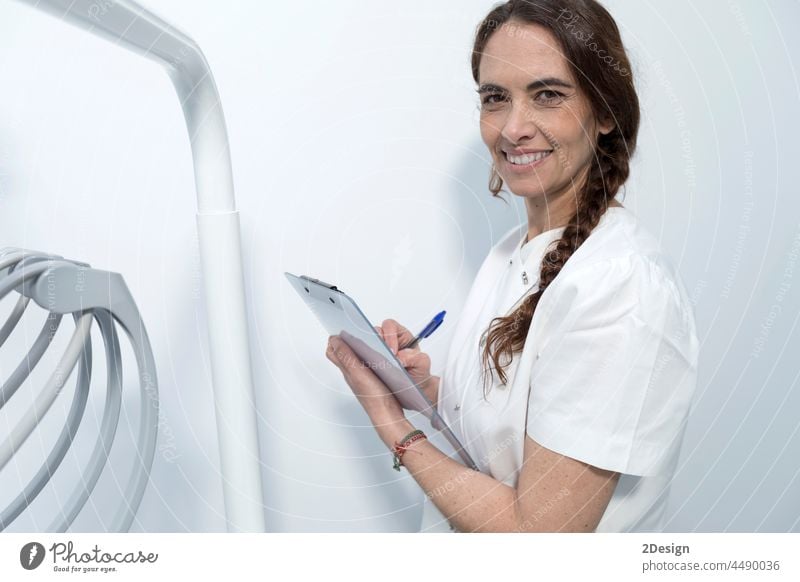 Portrait of confident experienced qualified happy smiling doctor holding clipboard with documents woman female health medical person care hospital medicine