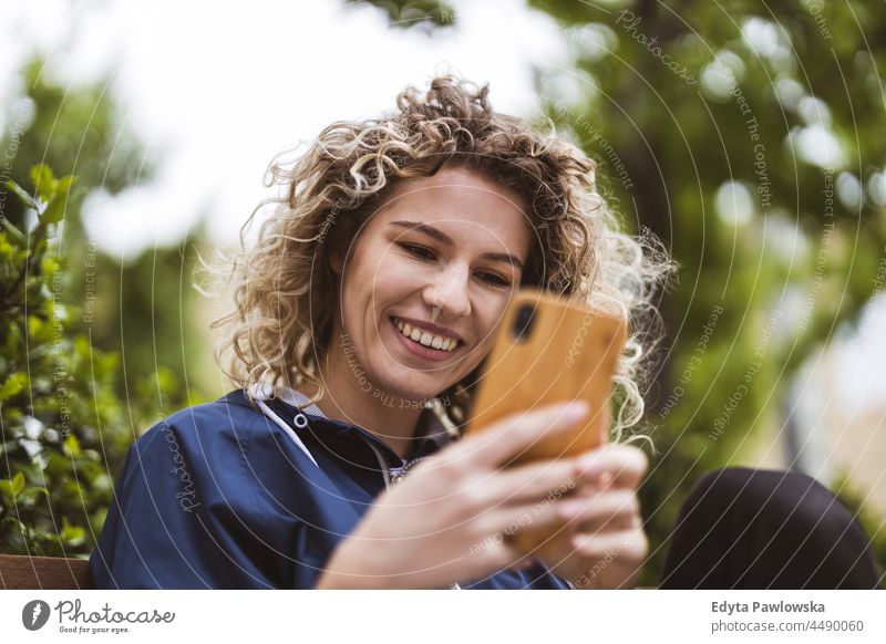 Young woman using mobile phone in the city Warsaw day fun curls hairstyle summer happiness outdoors tourist beauty smiling cheerful real people city life