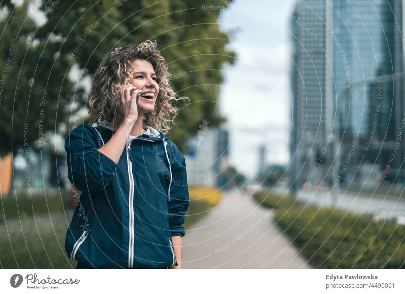 Young woman using mobile phone in the city Warsaw day fun curls hairstyle summer happiness outdoors tourist beauty smiling cheerful real people city life