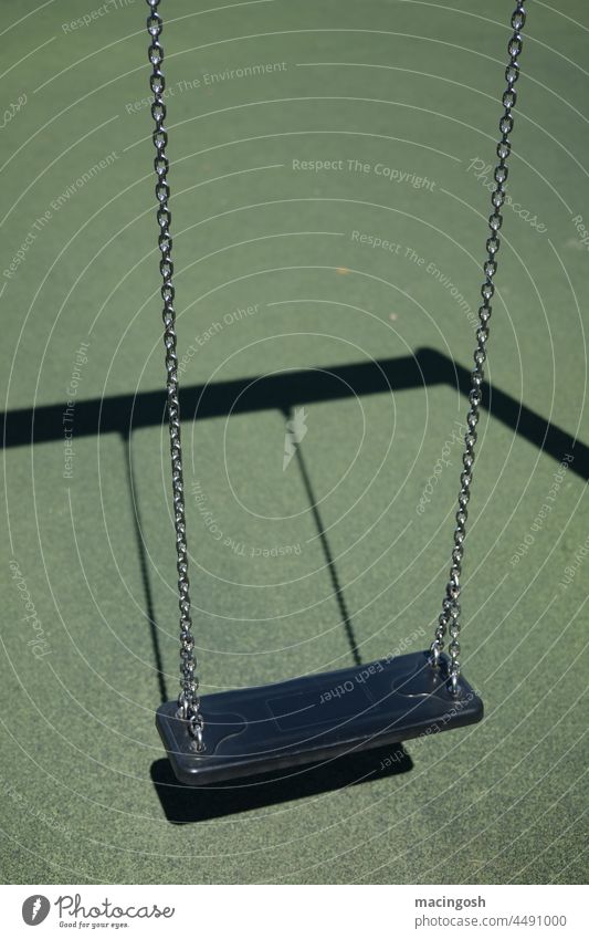 Empty swing on children's playground Swing Green Black Playground Deserted forsake sb./sth. Playing Exterior shot Infancy lockdown Child To swing Gloomy