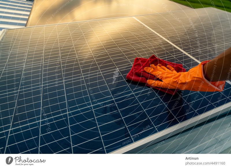 Man cleaning solar panel on roof. Solar panel or photovoltaic module maintenance. Sustainable resource and renewable energy for go green concept.  Solar power for green energy. Technology for future.