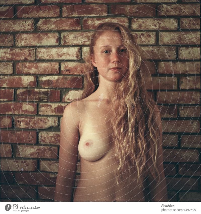 analogue nude portrait of a young woman with freckles and red hair standing in front of a brick wall Emanation tranquillity vigorous pretty Youth (Young adults)