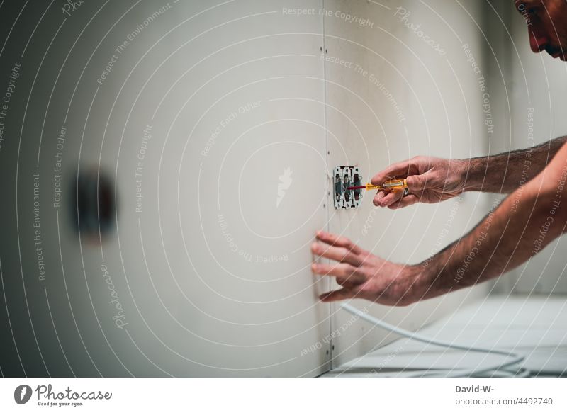 House construction - man checks a pipe - electricity Electricity phase tester Transmission lines electrician House building stream Build Energy power line Cable