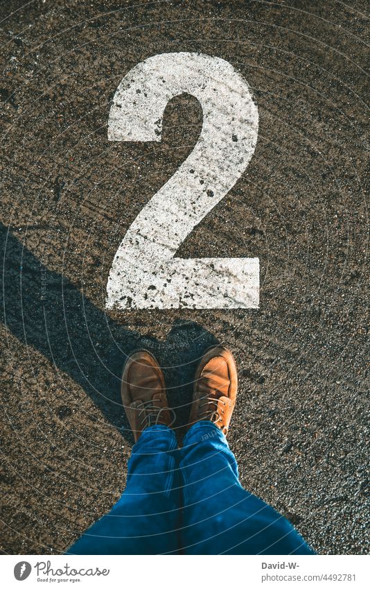 No. 2 - Man stands in front of the number two second digit Ground mark Ground markings Numbers