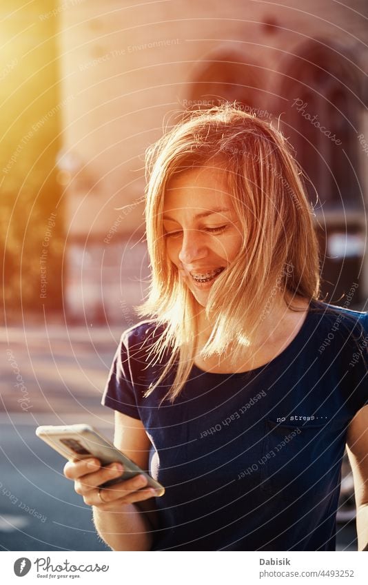 Woman with braces using smartphone at city street Smartphone Mobile Walking Street Lifestyle Communicate Online Portrait Phone Using Happiness Portable