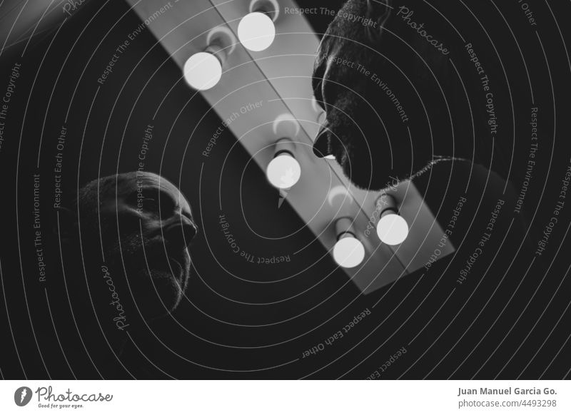 Middle-aged man looking in the mirror remember hide judge masculine bald darkness illumination knowledge depression identity show judgment mask lights time