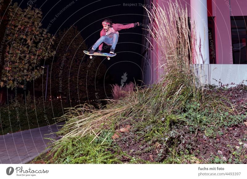 Skateboarder flies through the air skater Grave gave streetskateboarding skateboard deck Pro Hallowe'en session Red light skateboard trick tricks Sports urban