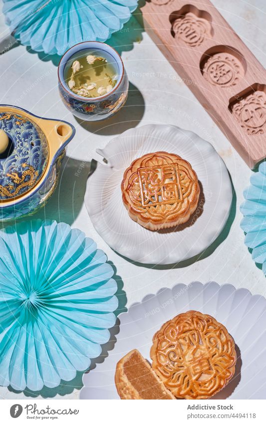 Sweet Chinese mooncakes near tea bakery pastry dessert chinese traditional sweet hot drink teapot food beverage treat cuisine culture tasty cut filling table