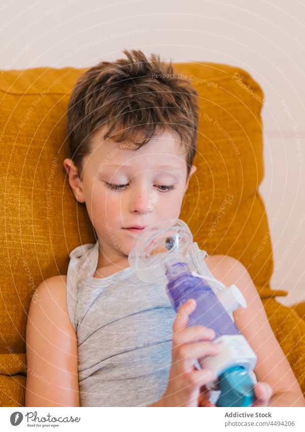 Ill child breathing in respirator with inhaler respiration breathe mask sick ill care medical boy health care oxygen asthma home illness cure sofa kid content