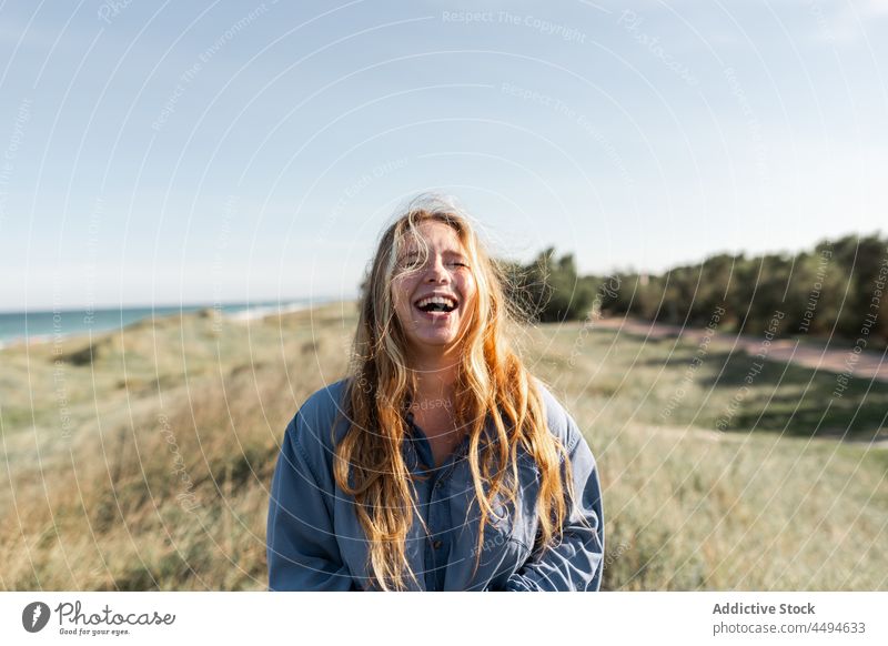 Happy woman standing in grassy meadow gesture summer happy nature field peaceful grimace smile glad female delight fun cheerful young lawn countryside positive