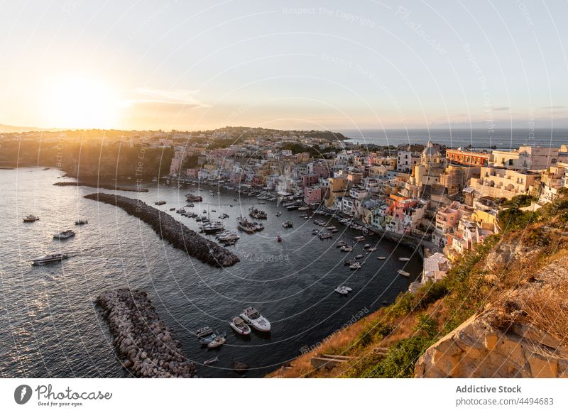 Picturesque coastal town with colorful buildings against sundown sky sea architecture boat sunset island travel sightseeing seascape residential picturesque