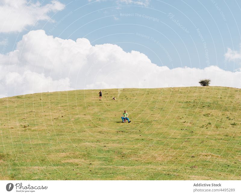 Unrecognizable kids riding bicycle on slope children ride hobby countryside childhood pastime leisure field rural summer recreation hill environment greenery