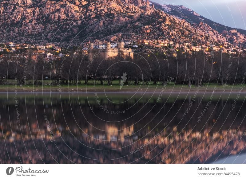 Calm sea near rocky shore with buildings water mountain town coastal waterside seaside environment settlement scenic house residential aqua flow river