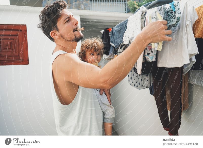 Young man doing the laundry at home clothes wash clean fresh doing laundry backyarkd family baby male modern masculinity youth parent outdoors aire warm dryed