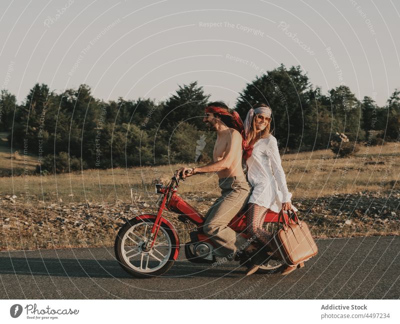 Hippie couple riding on moped relationship ride hippie nature journey trip freedom road countryside vehicle summer travel love boho bonding fondness roadway