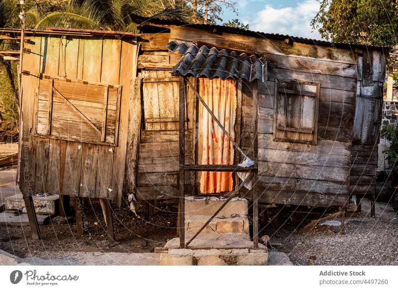 Aged abandoned wooden house against green trees village countryside poverty aged exterior old facade São Tomé and Príncipe africa nature rural residential