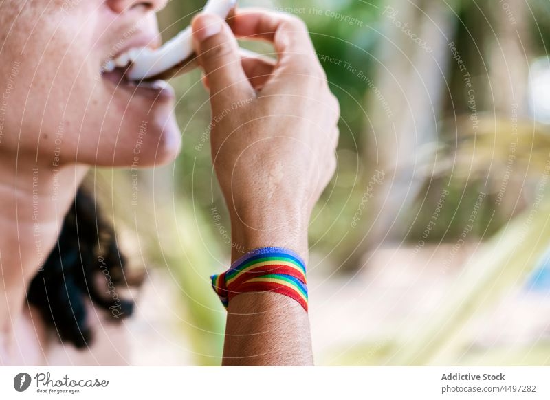 Person eating slice of coconut in summer time person bite fresh natural healthy tropical plant green São Tomé and Príncipe african organic lgbtq tolerance equal