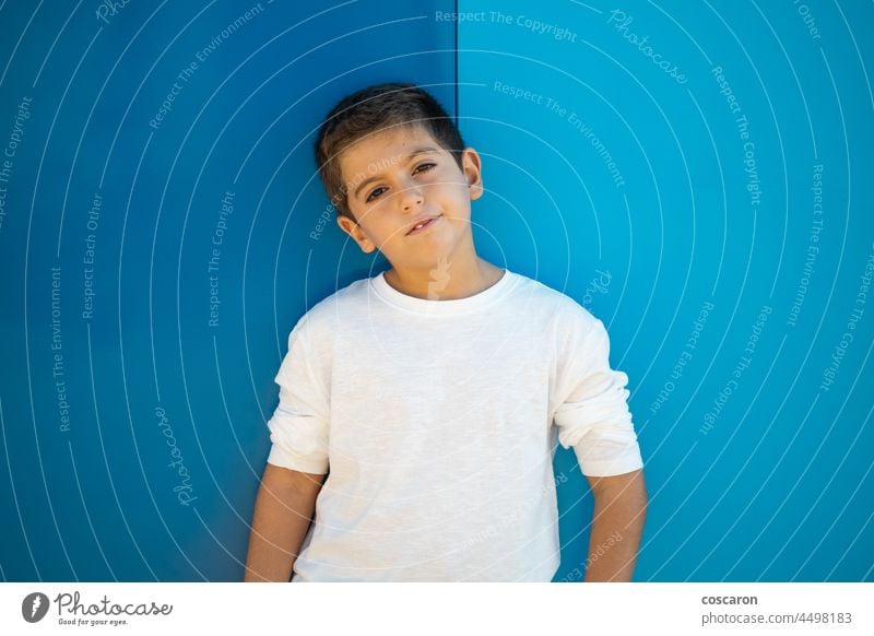 Pretty boy with a white t-shirt on a blue blackground attractive background beautiful blond carefree caucasian cheerful child childhood colorful cute emotion