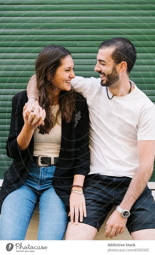 Joyful loving ethnic couple smiling and looking at each other on street laugh hug love cheerful relationship together romantic happy affection embrace date