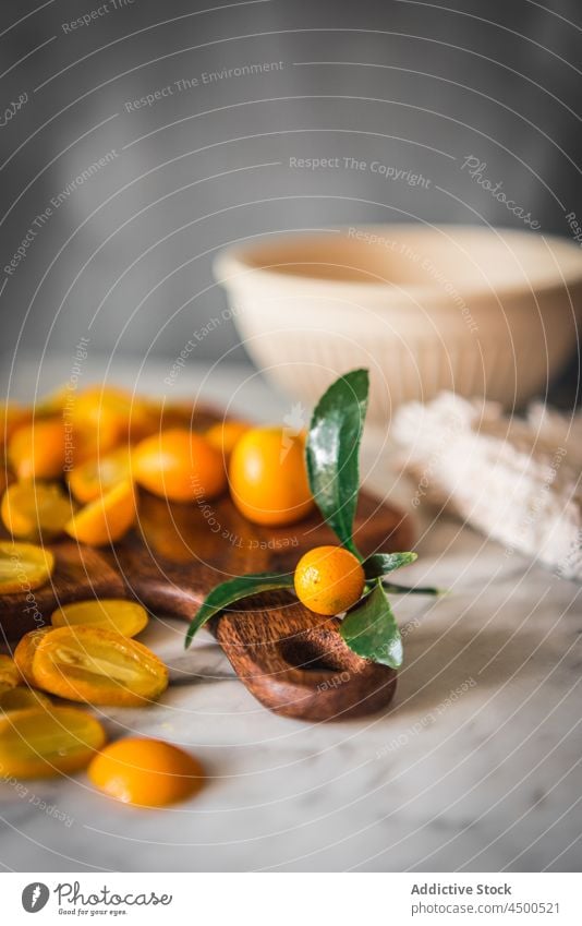 Heap of kumquats on cutting board fruit organic natural healthy food citrus vitamin kitchen fresh ripe wooden chopping board nutrition marble orange tasty pile