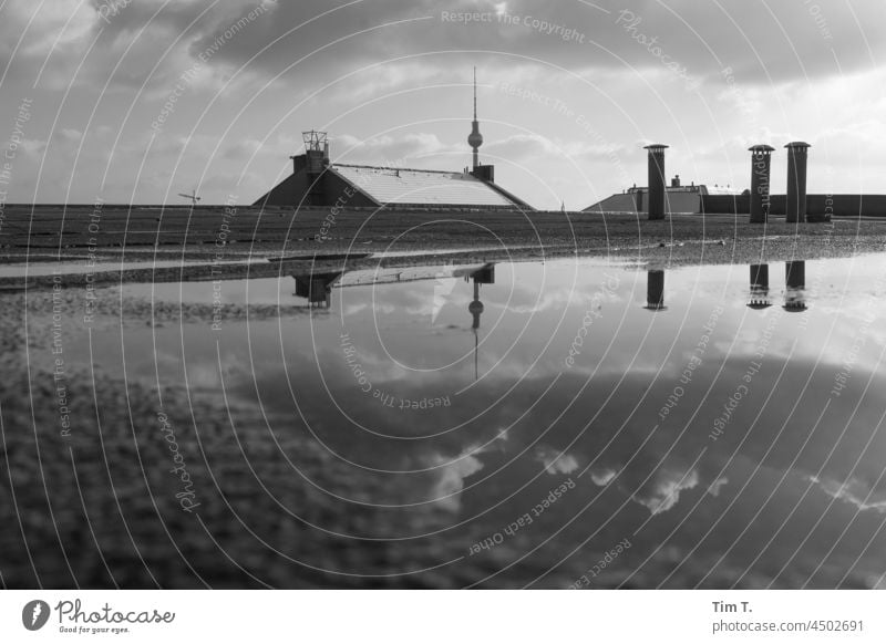 The TV tower and the clouds are reflected in a puddle on the roof Prenzlauer Berg chestnut avenue b/w bnw Television tower Roof Puddle Reflection Downtown