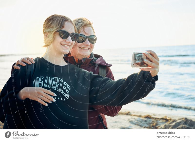 Happy women making video call on smartphone during trip on summer vacation chat gesture greeting taking photo selfie family person woman mobile phone holding