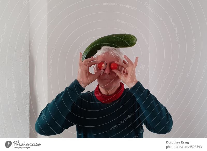 Man with tomatoes and zucchini older man Gray-haired Face Male senior tomatoes on the eyes Zucchino upside down Colour photo wittily Arcimboldo Vegetable