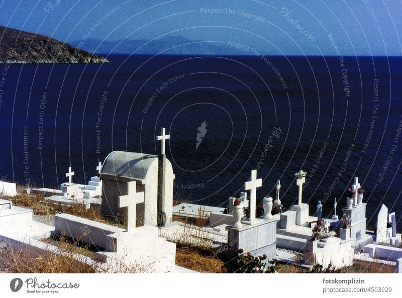 Sea view from a high cemetery with white graves and crosses on dark blue water Crosses Cemetery Ocean gravestones Graves Death Grief Tombstone Funeral