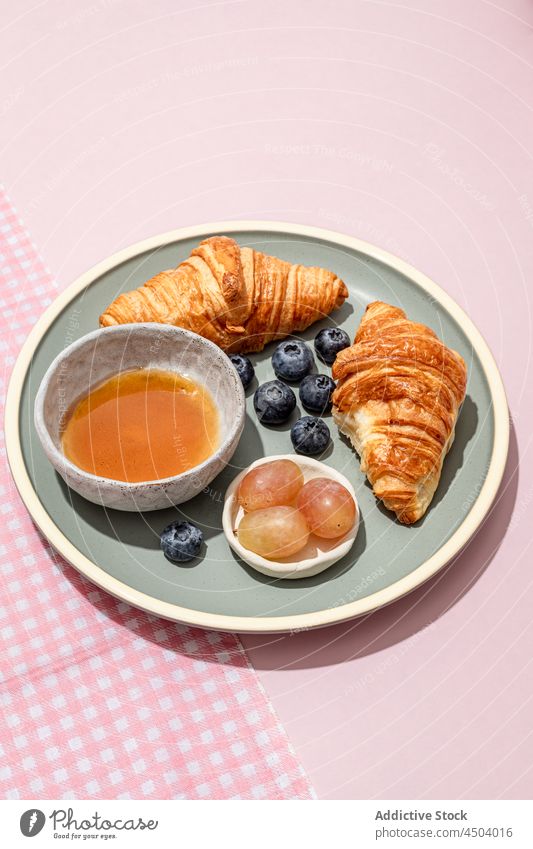 Plate with yummy croissants with blueberries and jam placed on table breakfast fresh delicious serve blueberry tasty food dessert sweet pastry plate baked