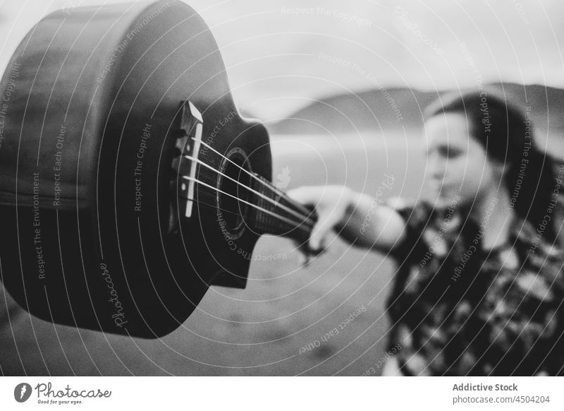 Woman musician reaching out hand with ukulele on beach woman sand calm thoughtful pensive reach out female tranquil acoustic nature stand alone instrument